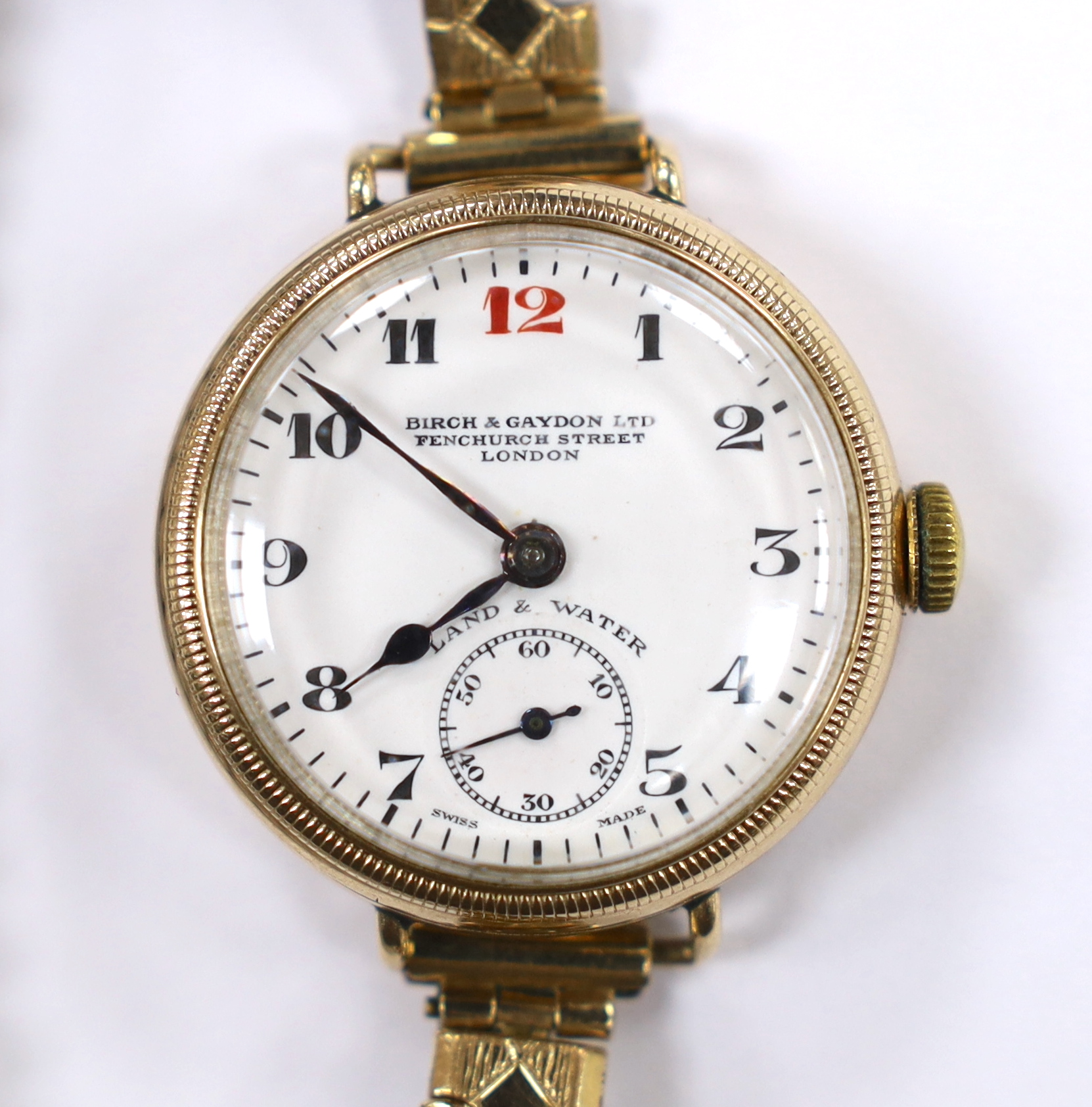 An early 20th century 9ct gold Zenith manual wind wrist watch, retailed by Birch & Gaydon Ltd, London, on a later steel and gold plated flexible strap, case diameter 30mm.